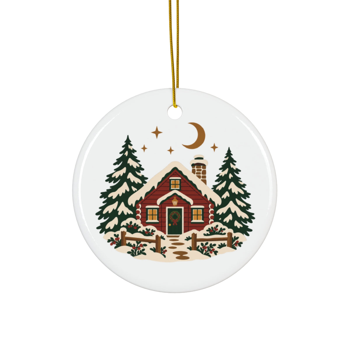 Round ceramic ornament with a snowy red cabin, pine trees, crescent moon and gold-colored string.